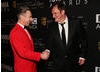 Ceremony host Alan Cumming shakes hands with director Quentin Tarantino.