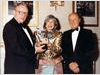 Mitzi Cunliffe is awarded a special version of her BAFTA Mask by Richard Price (l) and Johnny Goodman (r).