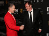 Ceremony host Alan Cumming shakes hands with director Quentin Tarantino.