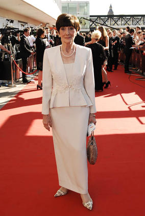 This cream coloured dress and matching jacket is incredibly sophisticated. June is the perfect example of a lady who dresses elegantly for her age. The flare at the bottom of the jacket gives the illusion of hips to June’s slim figure, and the tailored pencil skirt shows off her long legs. The cream colour works very well with June complexion, as she has a warm skin tone and dark eyes. Steer clear of cream or very pale pastels if you have very fair colouring, as it can easily wash you out.