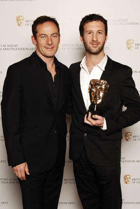 The Fallen director Morgan Matthews celebrates winning the Director Factual BAFTA with Harry Potter star Jason Isaacs (BAFTA / Richard Kendal).