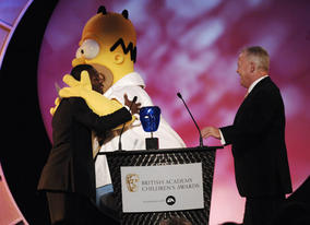 England footballer Shaun Wright-Phillips receives a warm welcome from Homer Simpson, whose movie won the BAFTA Kids' Vote in association with Electronic Arts
