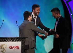 Chris O'Dowd and Miles Jacobson welcome Keith Ramsdale to the stage to accept the award for Use of Online of behalf on the development team behind FIFA 10 (BAFTA/Brian Ritchie)