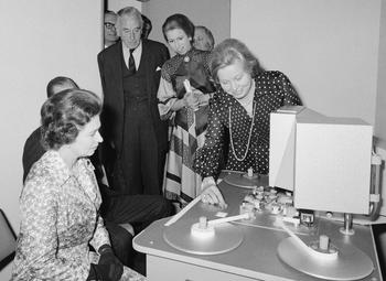 The Queen inspects a steenbeck in one of the viewing rooms at 195 Picadilly at the 1976 opening. Her Majesty The Queen