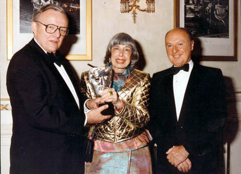 Mitzi Cunliffe is awarded a special version of her BAFTA Mask by Richard Price (l) and Johnny Goodman (r)